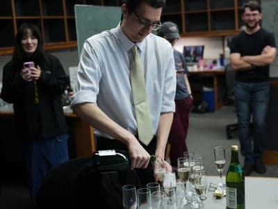 Newly minted PhD pouring champagne
